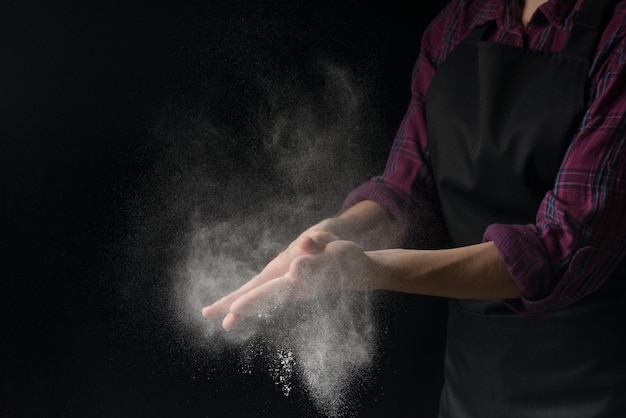 Cuocere le mani nella farina su uno sfondo di banner nero Fare la pasta per la pizza cuocere il pane e i dolci Con un posto vuoto per l'iscrizione o la pubblicità