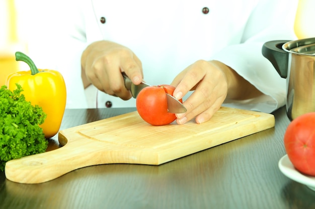 Cuocere le mani tagliando il pomodoro