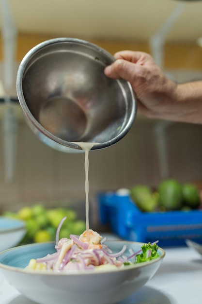 Cuocere versando la salsa su un piatto di ceviche