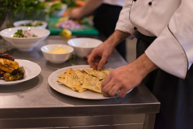 Cuochi e chef di squadra professionisti che preparano pasti nella cucina di un hotel o di un ristorante affollato