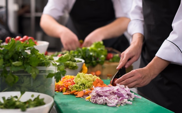 Cuochi e chef professionisti che preparano i pasti nella cucina affollata dell'hotel o del ristorante