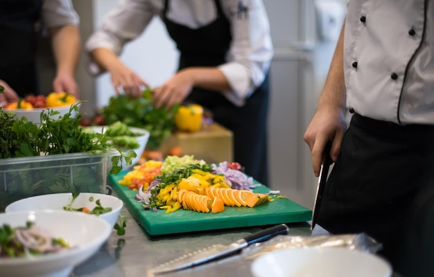 Cuochi e chef professionisti che preparano i pasti nella cucina affollata dell'hotel o del ristorante