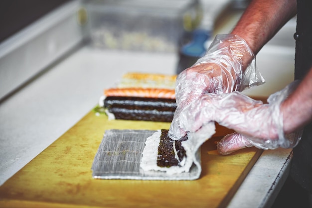 Cuochi maschi che preparano sushi nella cucina del ristorante.