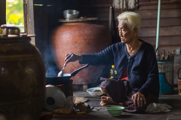 Cuoco asiatico senior del cuoco unico della donna nella cucina.