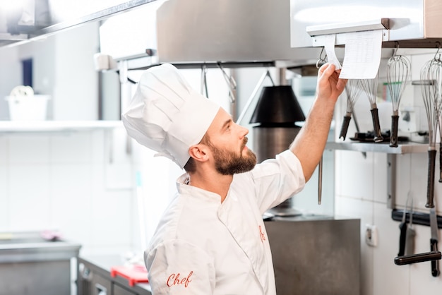 Cuoco chef che controlla l'ordine nella cucina del ristorante