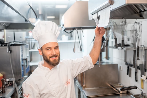 Cuoco chef che controlla l'ordine nella cucina del ristorante