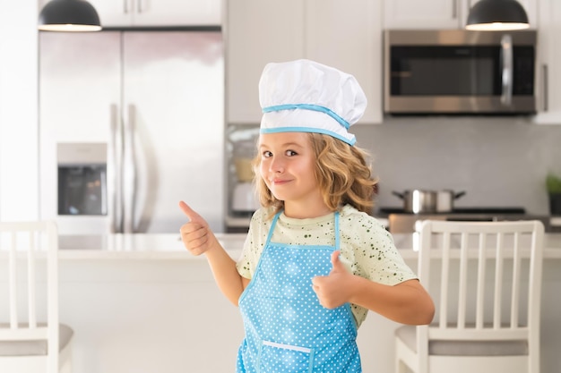 Cuoco cuoco bambino che indossa uniforme da cucina e cappello da chef che prepara il cibo in cucina Concetto di cucina culinaria e cibo per bambini