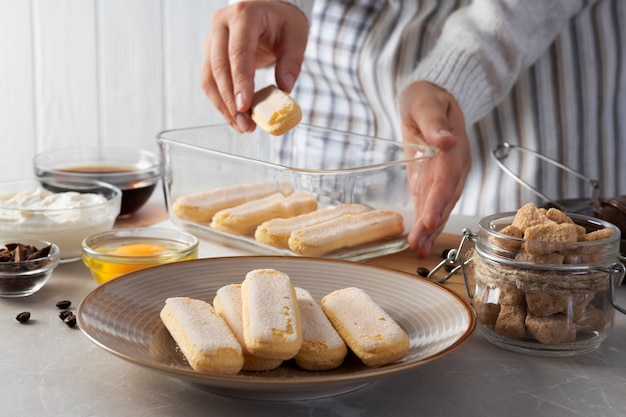 Cuoco di vista laterale che prepara il tiramisù