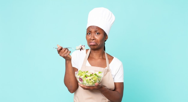 Cuoco unico adulto afroamericano nero che tiene un'insalata