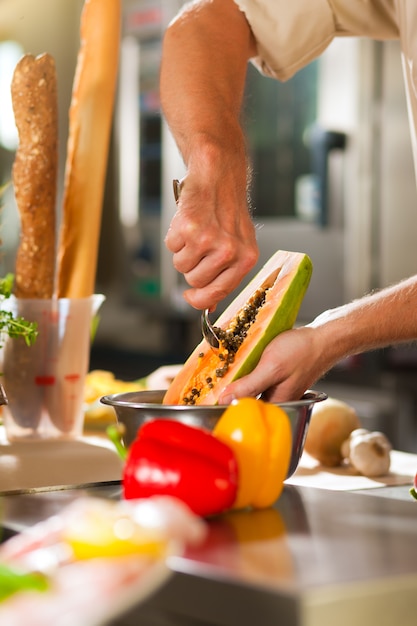 Cuoco unico che prepara i frutti nel ristorante o nella cucina dell&#39;hotel