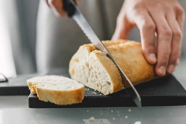 Cuoco unico che taglia pane italiano fresco