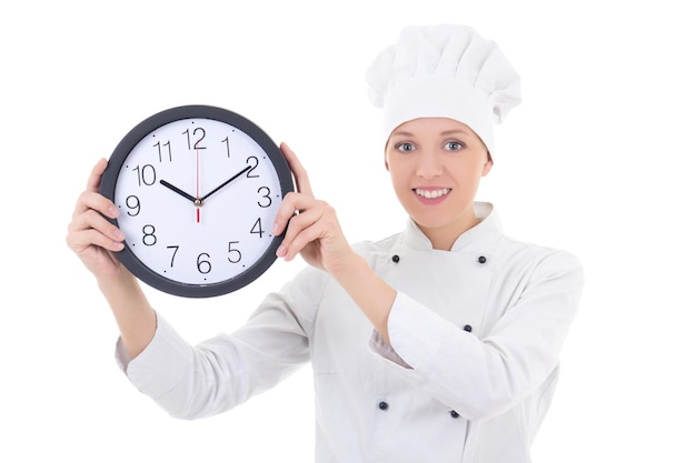 Cuoco unico felice della giovane donna nell'orologio dell'ufficio della tenuta dell'uniforme isolato su bianco