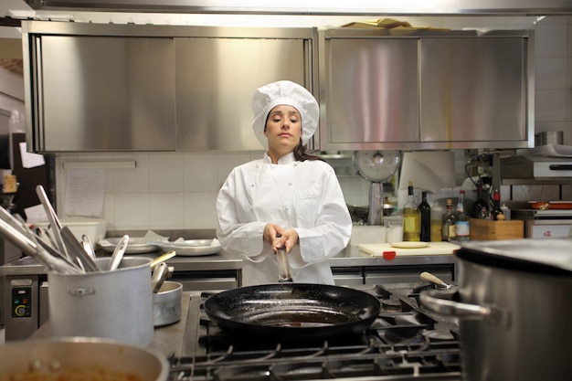 Cuoco unico femminile che lavora in cucina