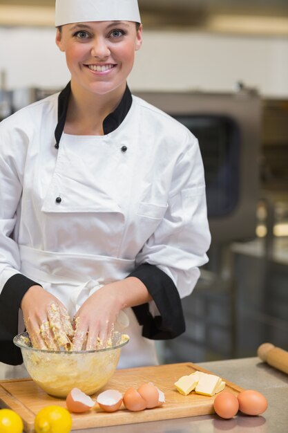 Cuoco unico sorridente che prepara la pasta