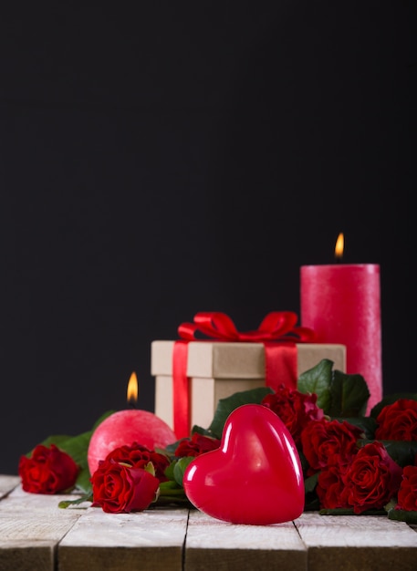 Cuore, candele e un mazzo di rose rosse