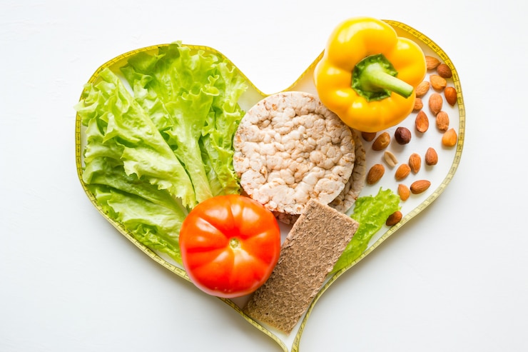 Foto cuore dal nastro di misurazione con le noci di verdure e la dieta di concetto di frutta