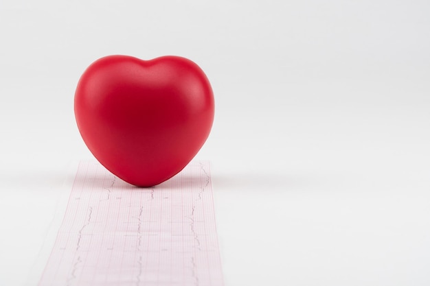 Cuore del giocattolo sul fondo dell'elettrocardiogramma. Sanità di concetto. Cardiologia - cura del cuore