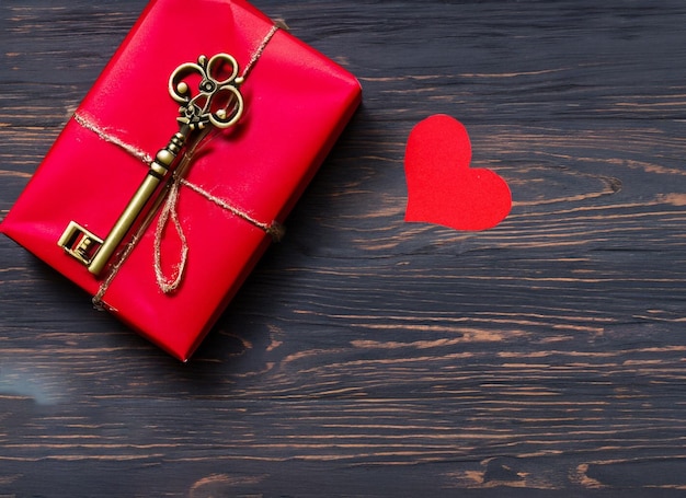 Cuore di carta rossa e vecchia chiave su uno sfondo di legno scuro Spazio per la copia del giorno di San Valentino