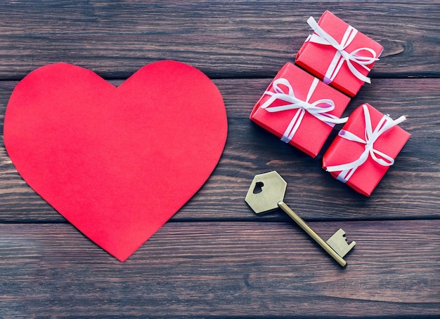 Cuore di carta rossa e vecchia chiave su uno sfondo di legno scuro Spazio per la copia del giorno di San Valentino