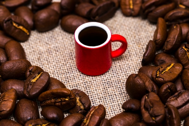 Cuore di chicchi di caffè e una tazza su tela