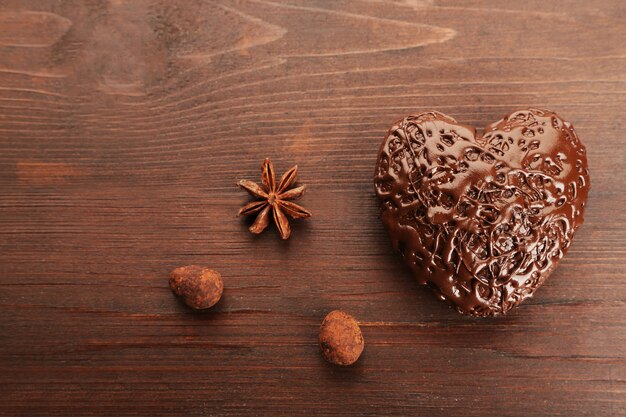 Cuore di cioccolato su uno sfondo di legno, primo piano