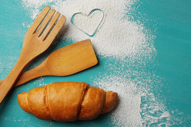 Cuore di farina, croissant su fondo di legno di colore