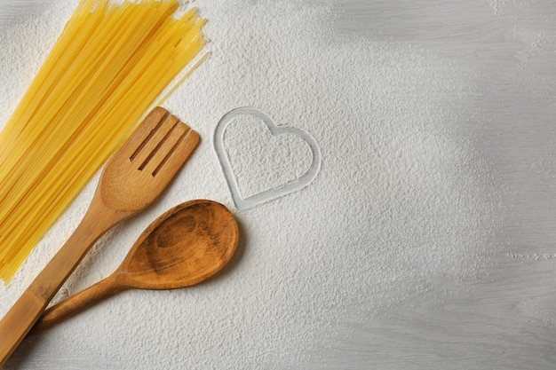 Cuore di farina e pasta su fondo grigio