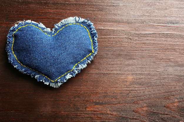 Cuore di jeans su fondo di legno