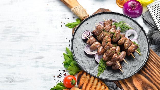 Cuore di pollo al forno su spiedini in un piatto nero Carne di pollo Vista dall'alto Spazio libero per il testo