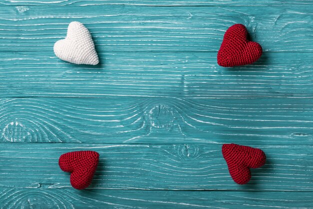 Cuore lavorato a maglia su sfondo blu di legno