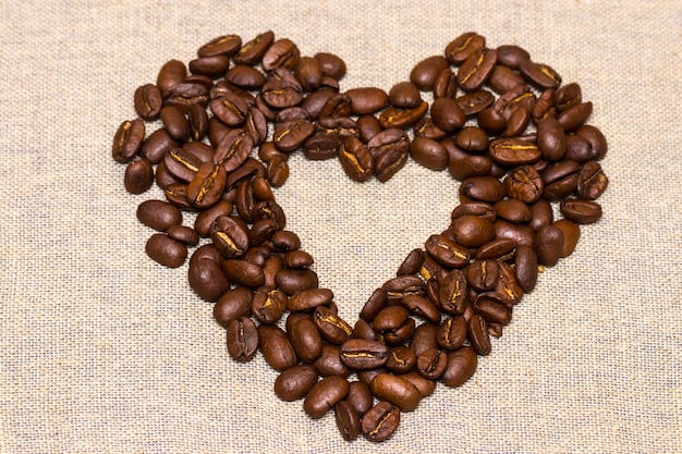 Cuore realizzato con chicchi di caffè impilati su tela di juta.