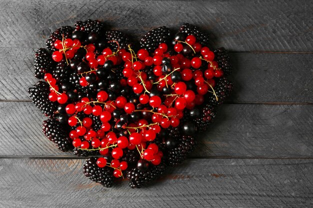 Cuore realizzato con frutti di bosco su un tavolo di legno