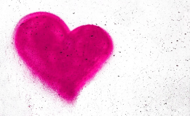 Cuore rosa a forma di cuore sullo sfondo di parete grungy con spazio di copia