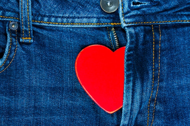 Cuore rosso al volo dei jeans. Sfondo per San Valentino.