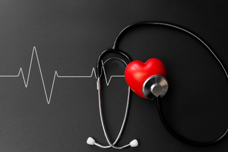 Cuore rosso e stetoscopio su carta nera. Elementi essenziali distesi per il medico che utilizzano il trattamento e la cura del paziente in ospedale.