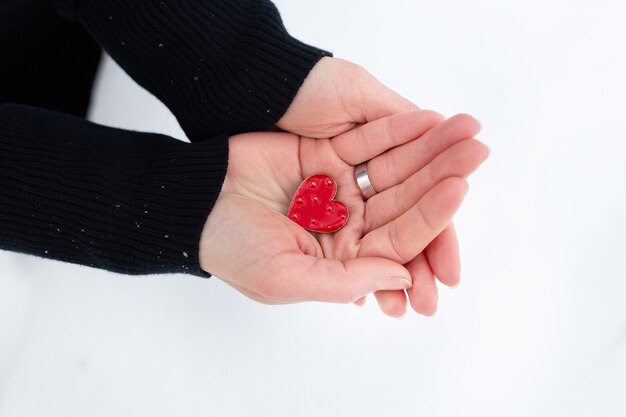 Cuore rosso nelle mani di una donna