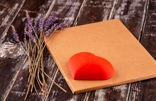 Cuore rosso sul mestiere busta vuota e fiori di lavanda su sfondo di legno concezioni romantiche