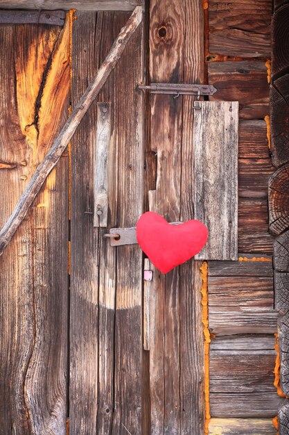 Cuore rosso sulla vecchia porta di legno.