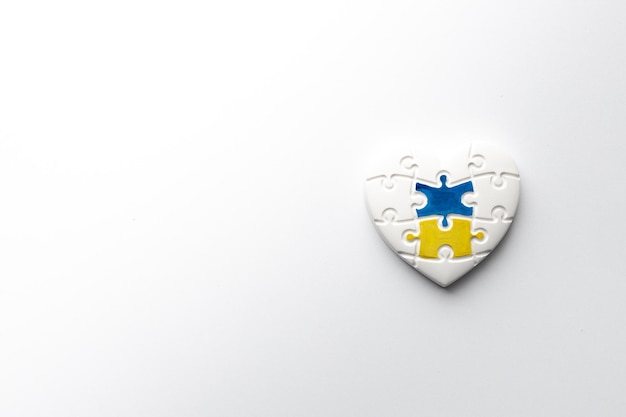 Cuore sotto forma di puzzle con i colori della bandiera dell'Ucraina su sfondo bianco