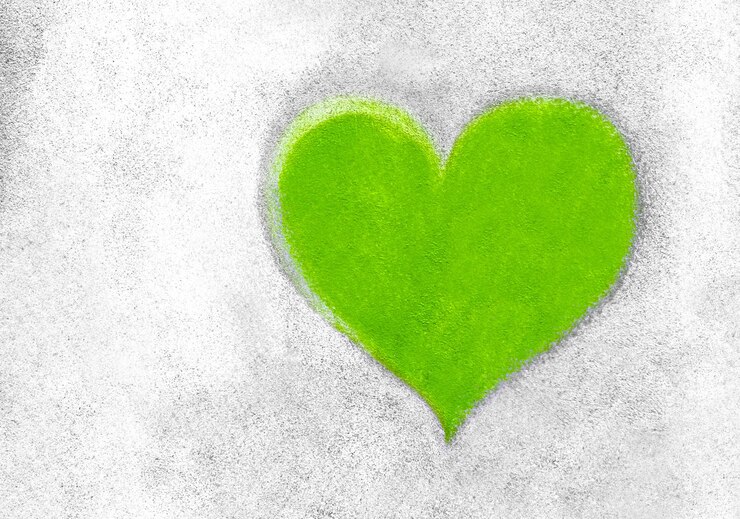 Foto cuore verde sul muro di cemento