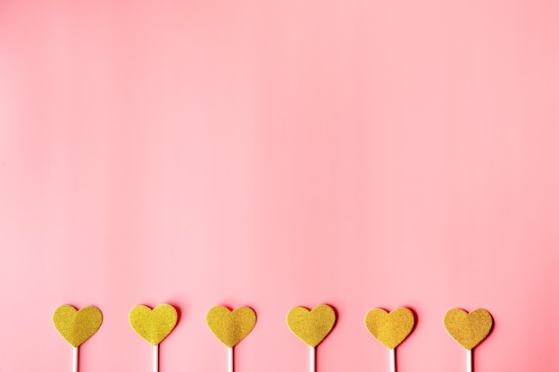 Cuori d'oro sul muro di carta rosa. Buon San Valentino, concetto di minimalismo cuori d'oro sul muro di carta grigia. buon san valentino, concetto di minimalismo