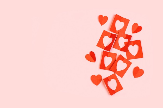 Cuori di carta rossa di San Valentino su sfondo rosa con spazio per la copia