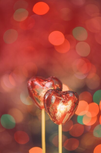 Cuori di cioccolato rosso avvolti in un foglio rosso per San Valentino Pila di cuore di cioccolato