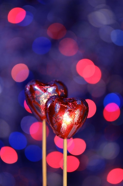 Cuori di cioccolato rosso avvolti in un foglio rosso per San Valentino Pila di cuore di cioccolato