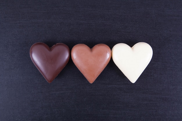 Cuori di cioccolato su uno sfondo scuro, close-up.