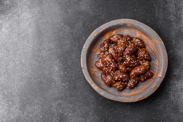 Cuori di pollo fritti in salsa di soia con sale e spezie in un piatto