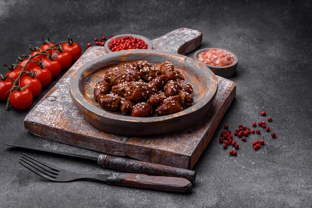 Cuori di pollo fritti in salsa di soia con sale e spezie in un piatto