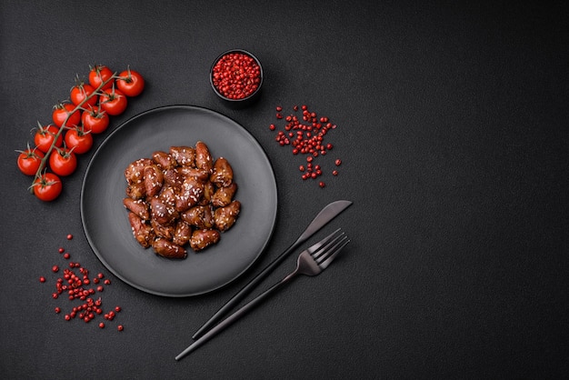 Cuori di pollo fritti in salsa di soia con sale e spezie in un piatto