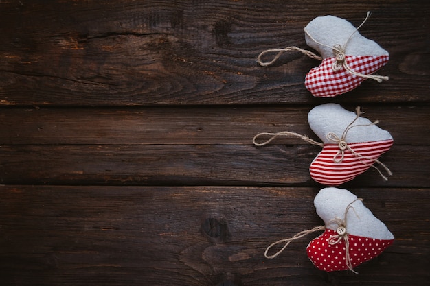 Cuori fatti di stoffa su fondo in legno