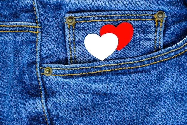 Cuori rossi e bianchi sulla tasca dei jeans. Sfondo per San Valentino.